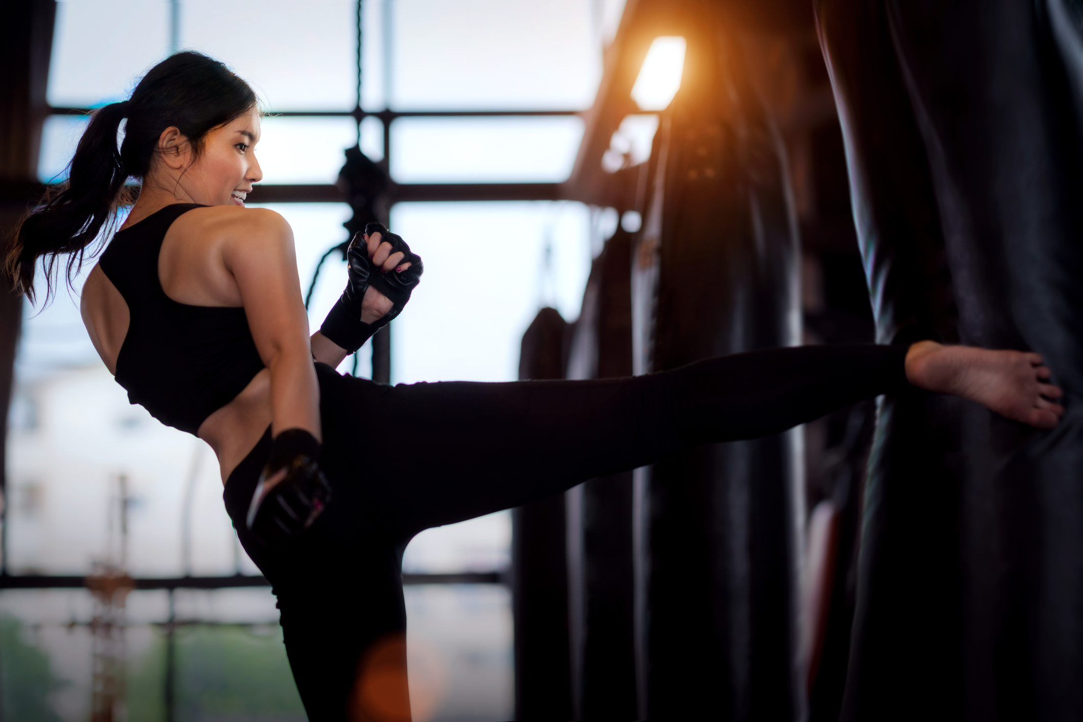 Woman kicking a Body Opponent Bag