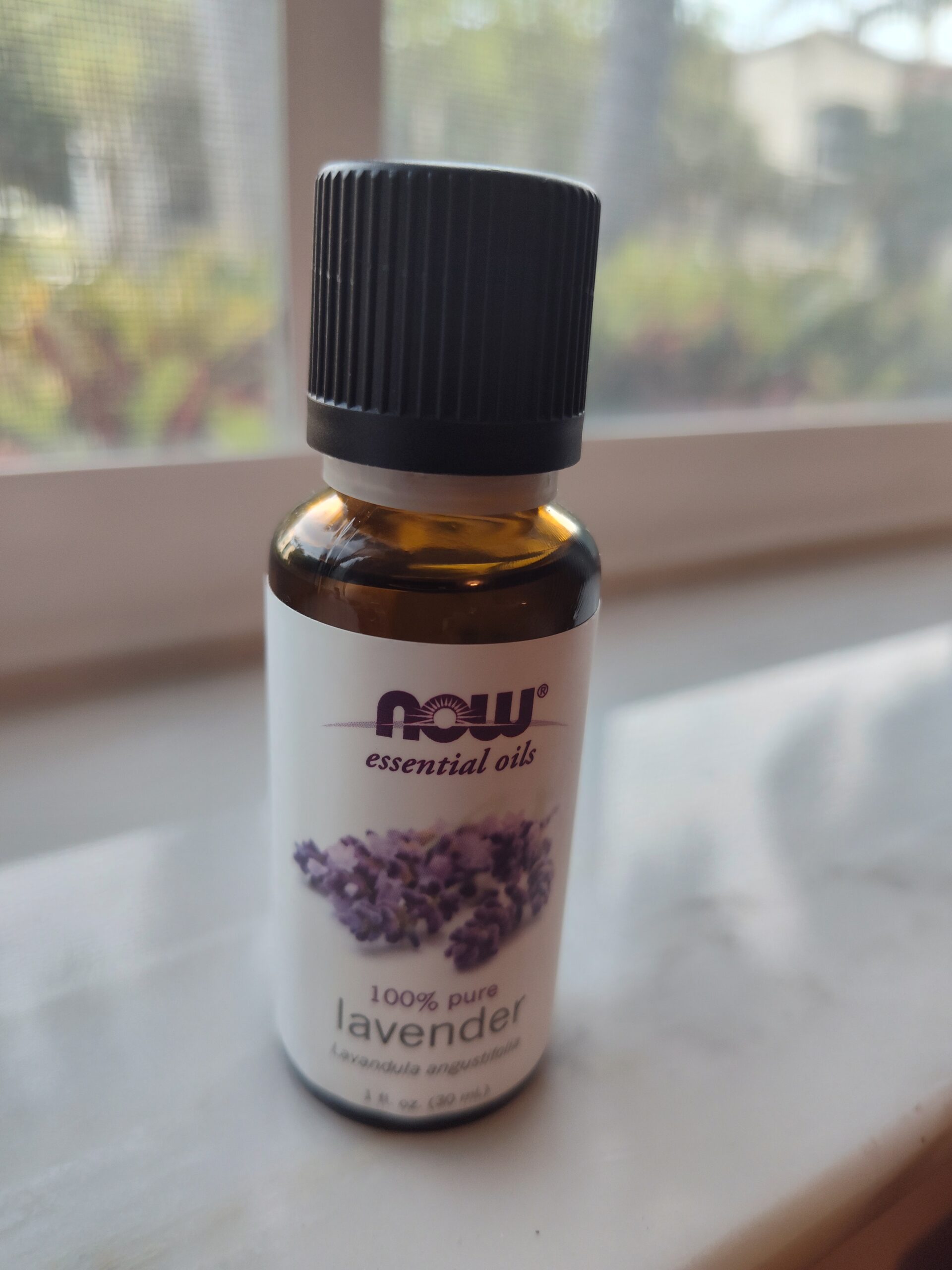 Bottle of NOW lavender essential oil on windowsill