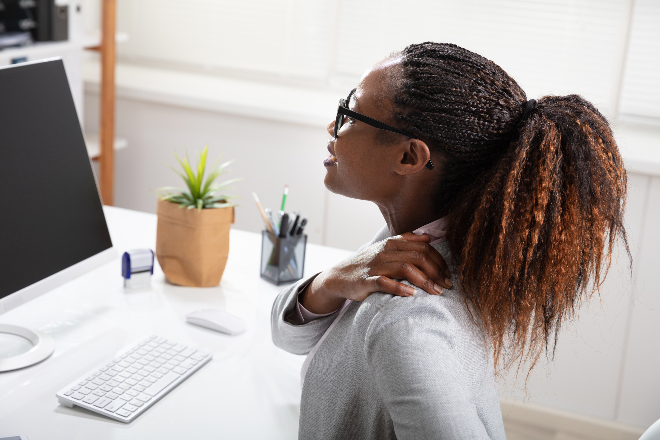 Black Woman sitting at computer with neck pain